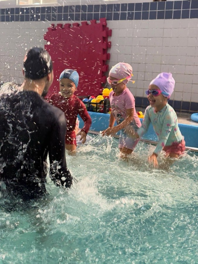 Professor brincando com as crianças na piscina
